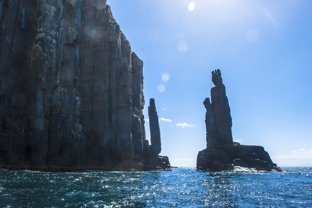 Iconic landmark of Steep high rocky cliff coast at Bruny Island, Tasmania, Australia, popular tourist destination at Southern Ocean, blue sky and copy space, filtered image.