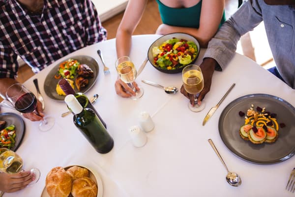 Friends enjoying food and wine at the table in a restaurant