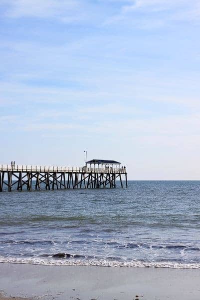 The tranquil waters and clear skies around the jetty at Grange Beach in Adelaide, offering a peaceful retreat and a stark contrast to the vibrant city life in Brisbane.