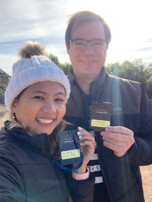 Me and my husband smiling for a selfie while displaying our tour badges for Blinman Mine Tour, highlighting the personalised experiences available for visitors looking for things to do in the Flinders Ranges.