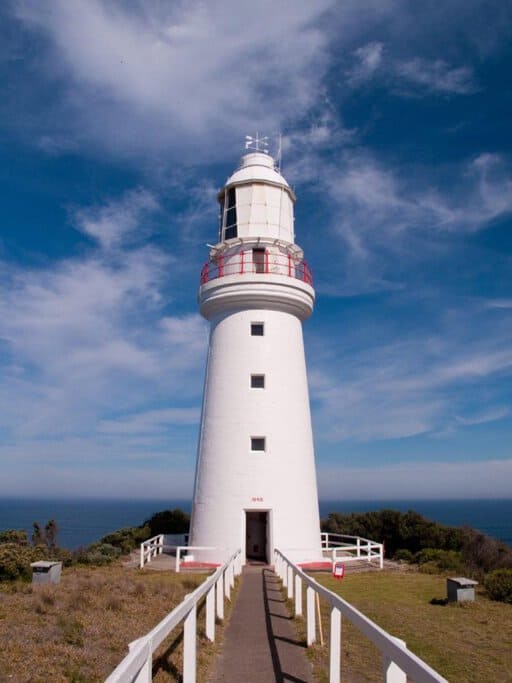 Cape Otway Lighthouse on the Great Ocean Road, Australia, surrounded by greenery and overlooking the ocean. This iconic landmark is near unique Great Ocean Road accommodations, offering visitors a chance to stay close to nature and history.