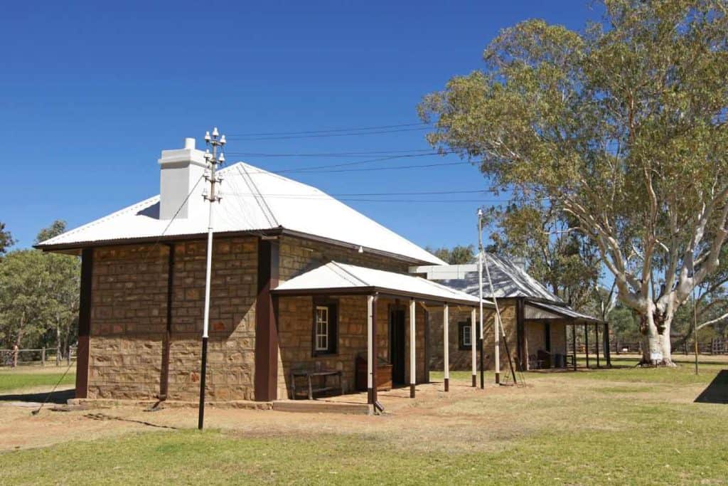 The Old Telegraph Station in Alice Springs, a historic stone building surrounded by gum trees, providing a glimpse into the town's early communication history and a key stop for those visiting Alice Springs.