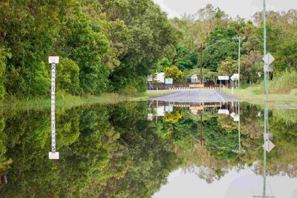 A flooded road with depth indicators and beautiful reflections