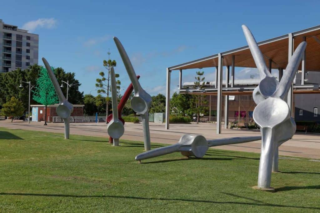 Large metal bird sculptures at Bluewater Quay in Mackay, set against a backdrop of modern buildings and public space—highlighting the blend of art, lifestyle, and urban development often weighed when exploring whether living in Mackay is right for you.
