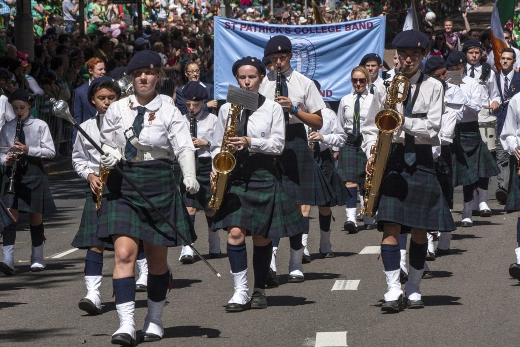 St Patrick’s College marching band in kilts playing saxophones and drums during the St Patrick’s Day parade in Sydney, showcasing the lively music and traditional Irish spirit that define St. Patrick’s Day celebrations in Sydney.
