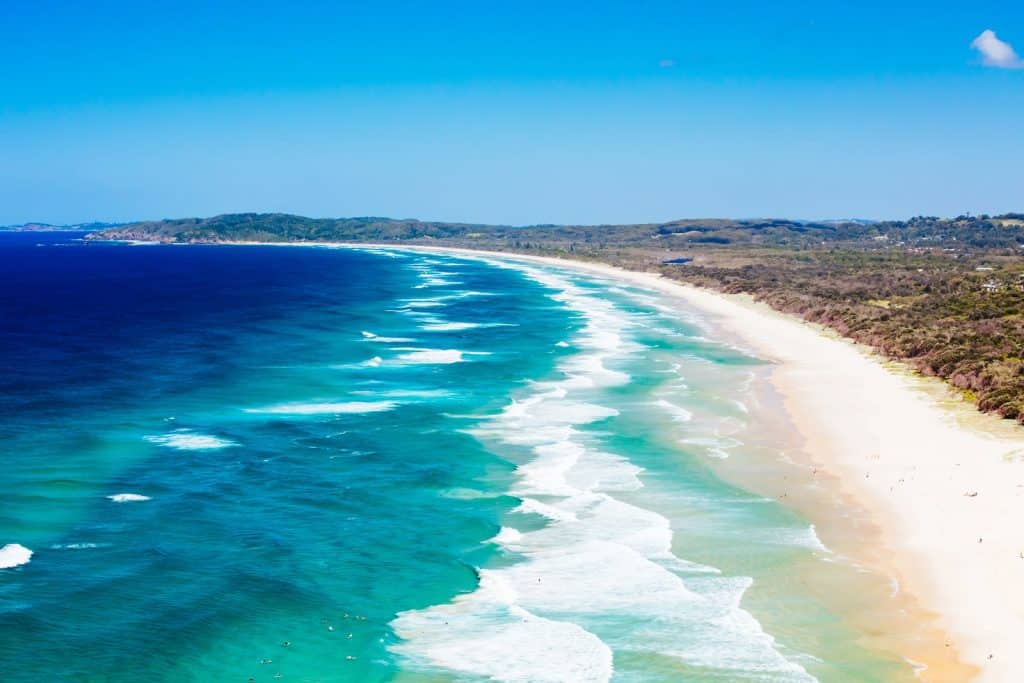 Aerial view of turquoise waves rolling onto a long stretch of white sand at Tallows Beach in Byron Bay, highlighting why this coastal paradise is often listed among the best beaches in Australia and featured in the post about Australia’s Best Beaches.