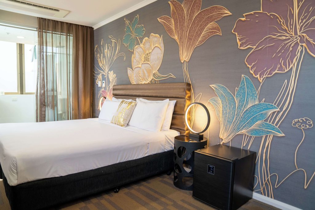 Stylish boutique hotel room with floral wall mural and modern decor in Surry Hills Sydney, highlighting boutique accommodation in one of the best neighbourhoods in Sydney for first-time visitors Sydney