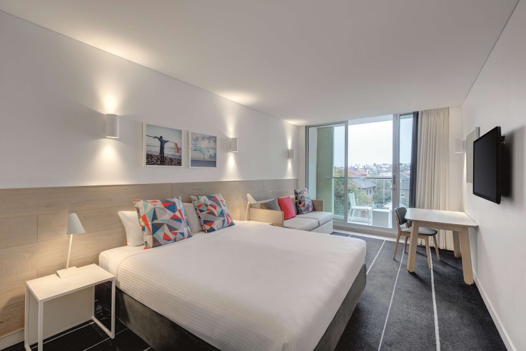 Modern apartment-style hotel room with balcony at Adina Apartment Hotel Bondi Beach Sydney, highlighting comfortable Bondi Beach accommodation in one of the best neighbourhoods in Sydney for relaxed coastal stays