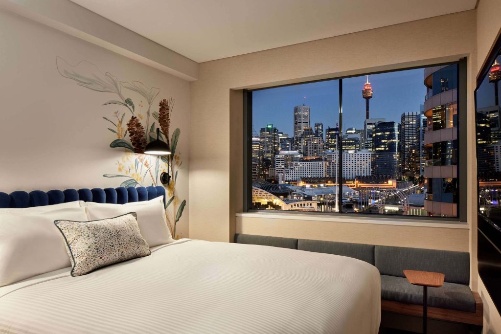 Hotel room with large window overlooking Sydney skyline and Darling Harbour at night, highlighting Darling Harbour hotels and a great location in the Sydney accommodation guide for first-time visitors Sydney