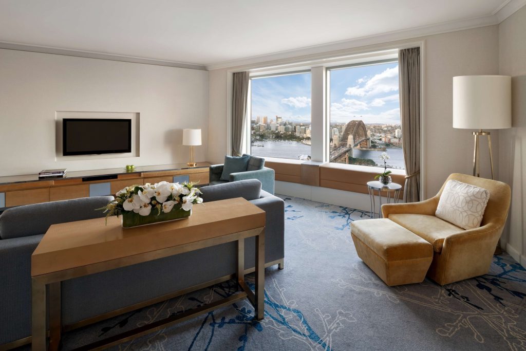 A spacious luxury suite at Shangri-La Sydney in The Rocks featuring elegant furnishings and sweeping views of the Sydney Harbour Bridge and harbour, one of the best hotels near the Sydney Harbour Bridge for a five-star stay.