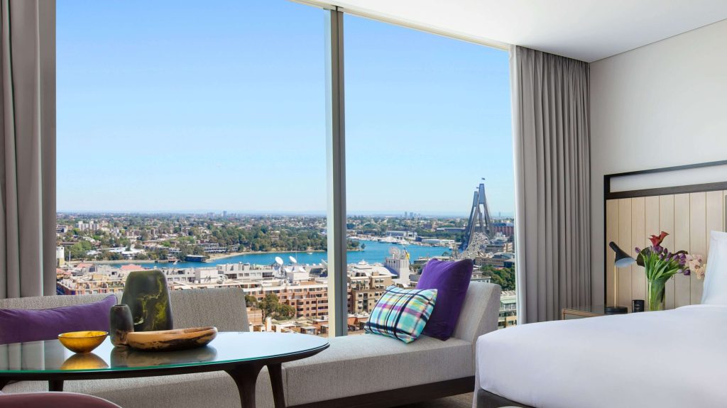 Luxury hotel room with floor-to-ceiling window overlooking Sydney Harbour and the Harbour Bridge, highlighting a Sydney hotel with harbour view and luxury hotels in Sydney in one of the best areas to stay in Sydney