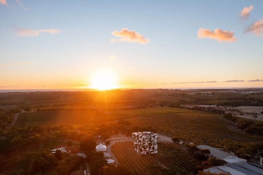 The sun sets over vineyards and rolling countryside in the McLaren Vale wine region near Adelaide. A wine tasting day trip is one of the best things to do near Adelaide.