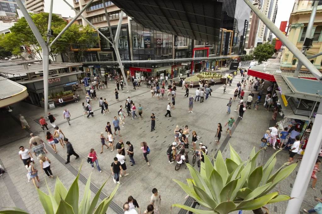 Crowds walking through Queen Street Mall in central Brisbane surrounded by shops and city buildings. Exploring the busy pedestrian mall is a popular Brisbane activity for shopping and experiencing the city centre.