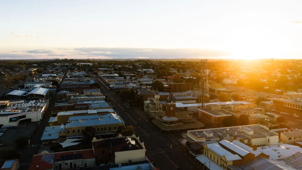 Aerial view across Broken Hill in Outback New South Wales at sunset with golden light illuminating the city. Broken Hill is a memorable stop while driving from Brisbane to Perth across Australia.
