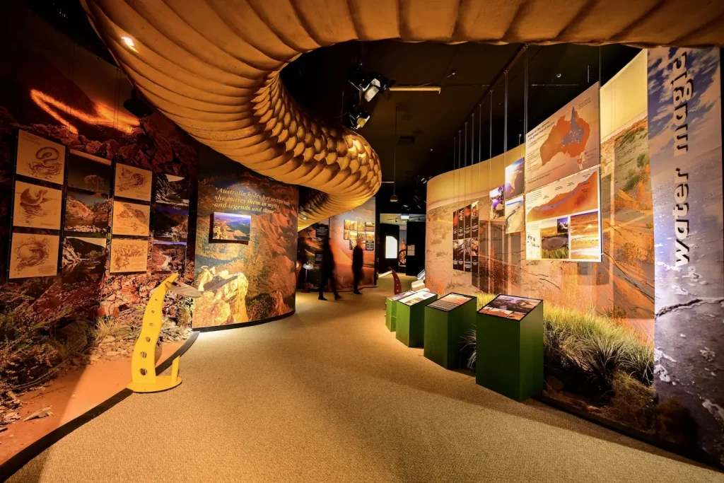 Outback exhibition in Port Augusta with landscape displays and a large suspended snake model overhead. The visitor centre is a cultural stop on the Brisbane to Perth driving route through South Australia.