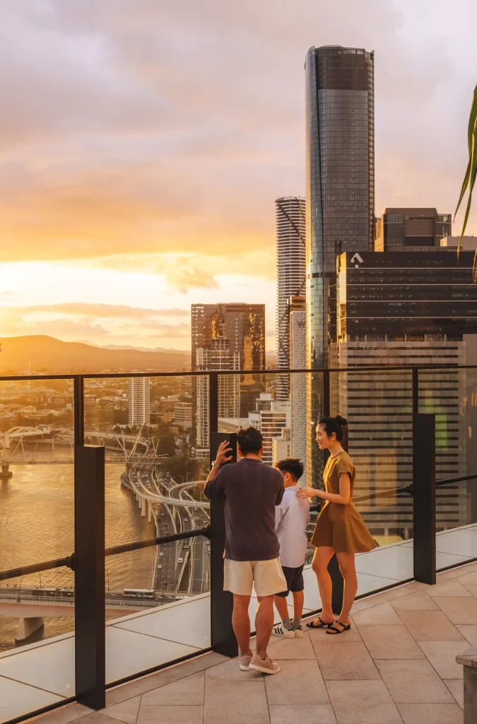 Visitors admire the Brisbane skyline and river at sunset from the Sky Deck at The Star Brisbane Observation Deck. The panoramic outlook highlights why rooftop drinking spots in Brisbane are known for spectacular city views.