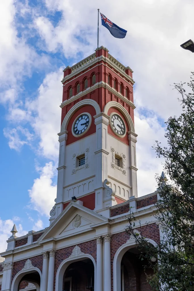 Red and white heritage clock tower rising above Toowoomba City beneath a partly cloudy sky. Toowoomba marks an early stop on the cross country drive from Brisbane to Perth.