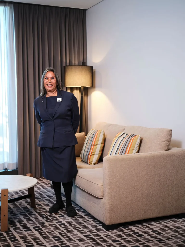 A cosy suite with a beige sofa, floor lamp and round marble table at Novotel Perth Murray Street, a central pick for Perth hotels with a swimming pool