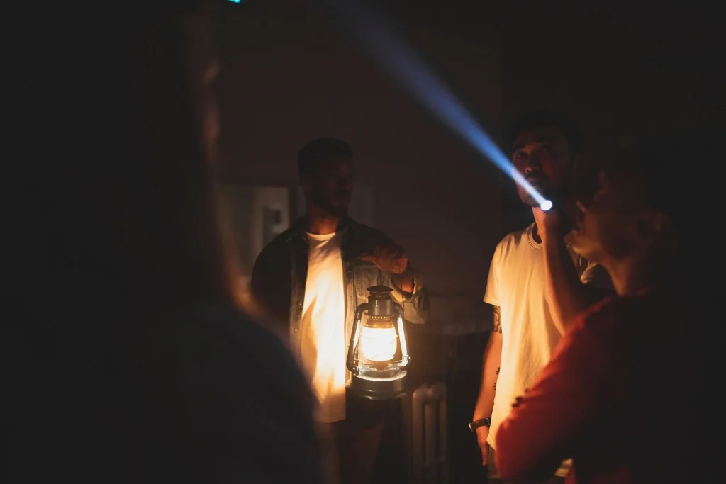 A small group listening to ghost stories by lantern light at Q Station, one of the spookiest things to do in Sydney after dark