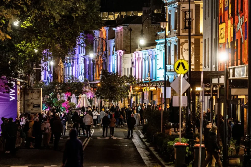 A busy night-time street in The Rocks lined with heritage pubs and shops, a favourite route for ghost walks in Sydney